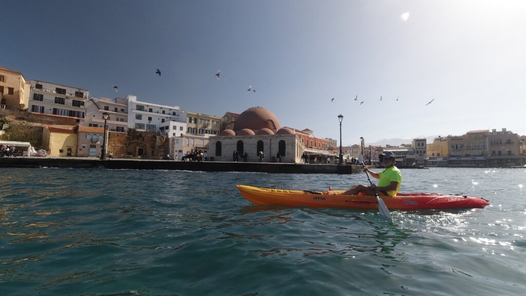 A person on a sea kayak in Chania old harbour